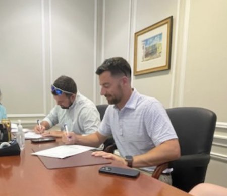 Chris Lawlor signing at the closing table on one of his own property purchases