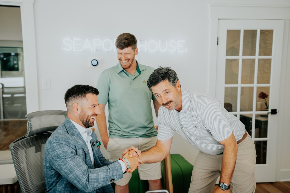 Chris Lawlor shaking hands with colleagues at the Seaport House office