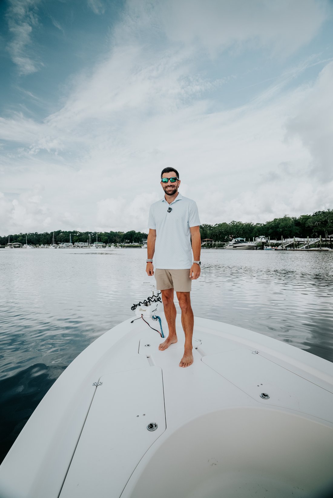 Chris Lawlor on the bow of a boat on the water near Dutch Island, Savannah