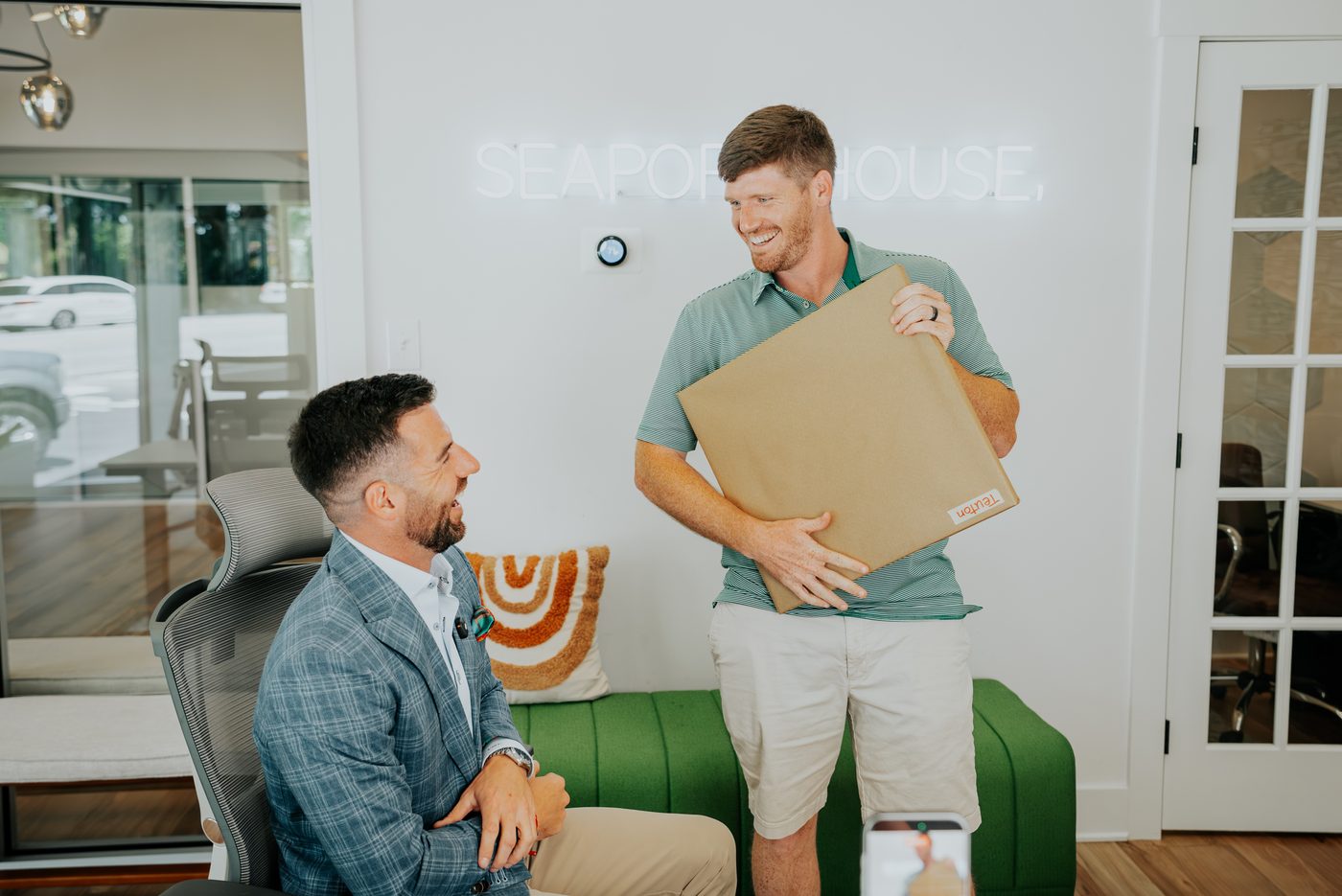 Chris Lawlor laughing and shaking hands with a colleague at the Seaport House office